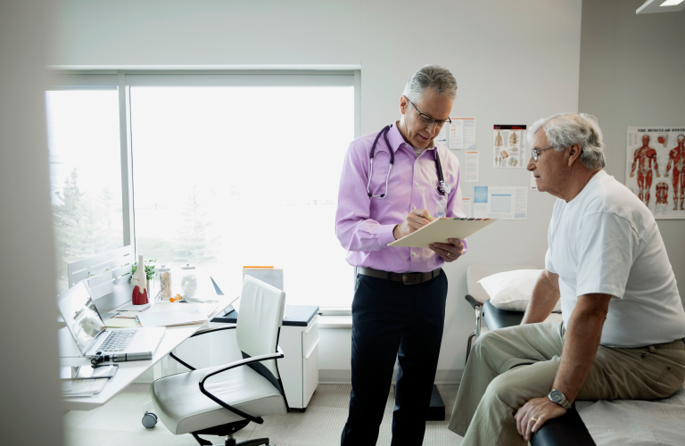 Doctor reviewing medical chart with senior man