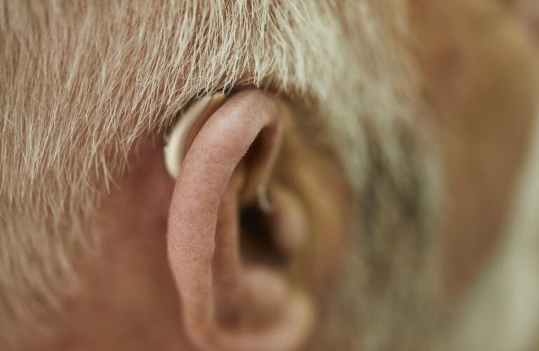 Close-up of back of senior Caucasian man's ear with hearing aid