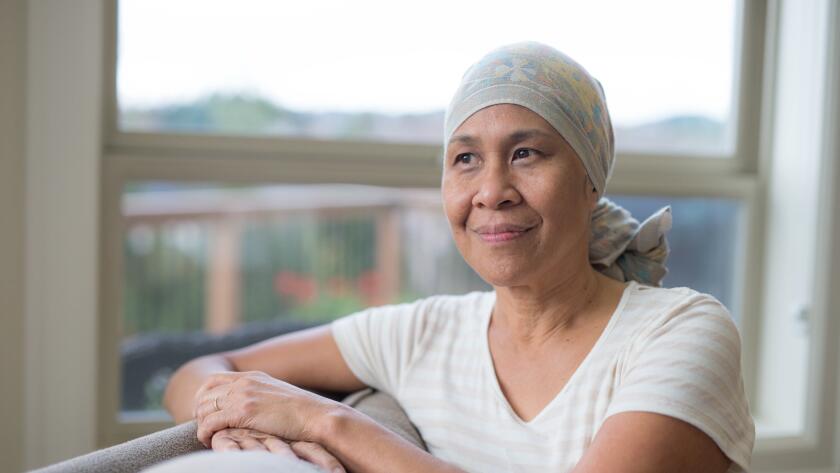 cancer patient sitting by window in head wrap
