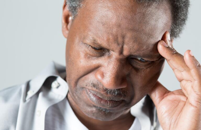 fatigued senior man with hand on head