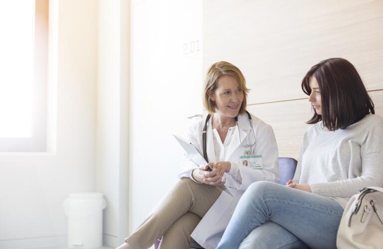 female doctor reviewing medical charts with female patient