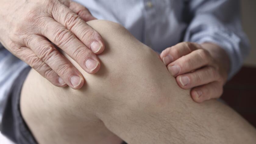 man-with-hands-on-sore-knee