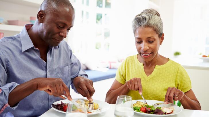 mature couple eating dinner at table