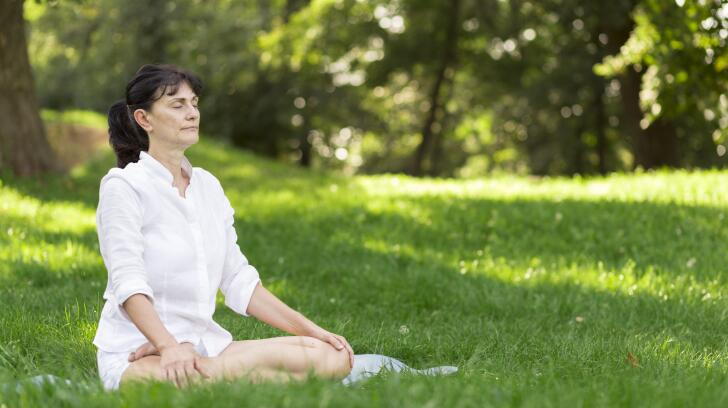 woman meditating in field outside