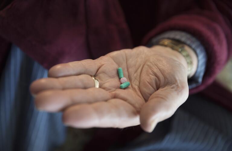 senior-man-holding-pills