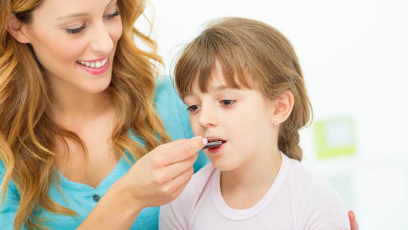 Mother giving medicine to child