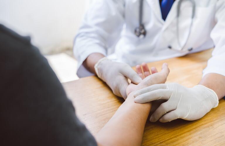 midsection of doctor examining patient's wrist