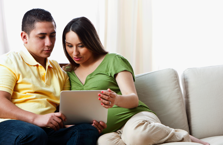 pregnant couple on computer