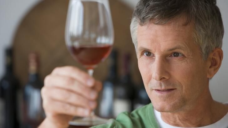 man-looking-at-glass-of-red-wine