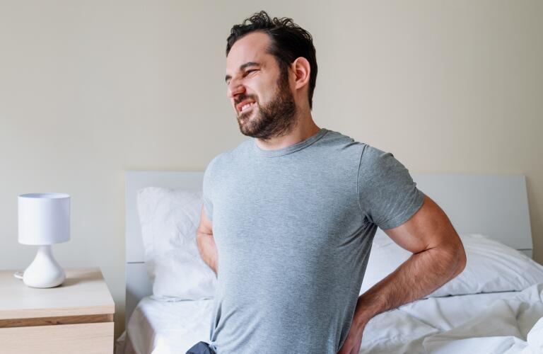 Man feeling backache after sleeping in bed