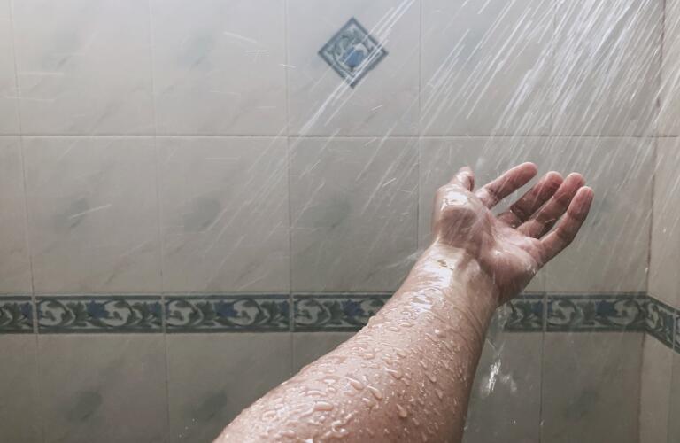 water spraying on hand in shower