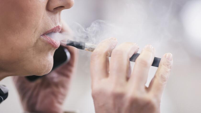 closeup of senior Caucasian woman vaping with electronic cigarette