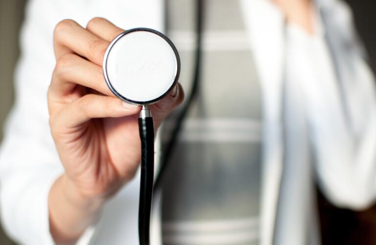 female doctor holding up stethoscope