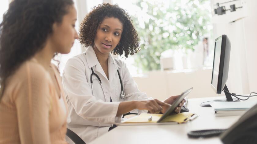 Doctor and patient using digital tablet in office