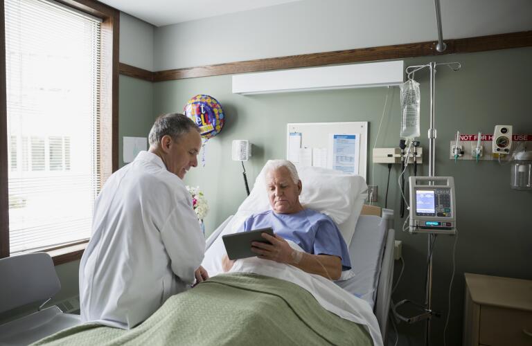 Doctor and patient using digital tablet in hospital