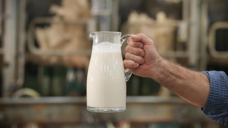 man-holding-out-pitcher-of-milk