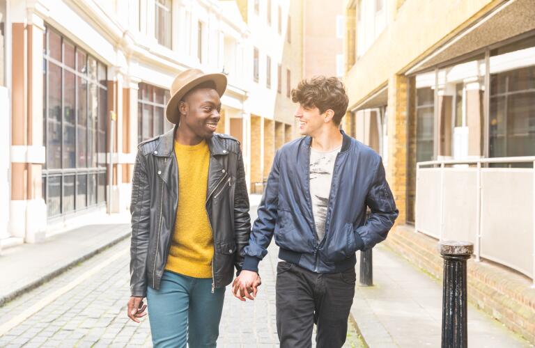 smiling couple holding hands walking down empty street