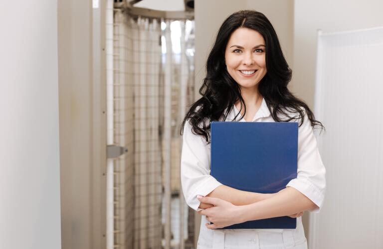 smiling female dermatologist holding files