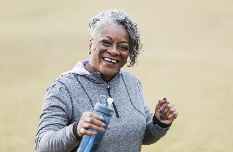 senior woman smiling with water bottle