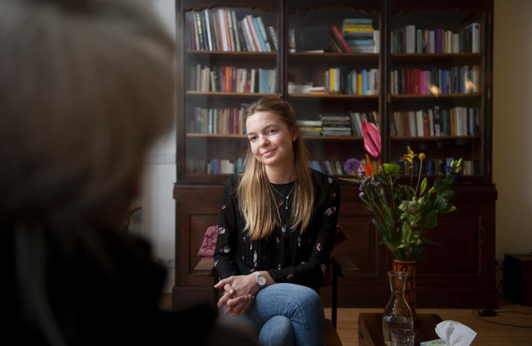 Young Caucasian woman talking to therapist or counselor in office