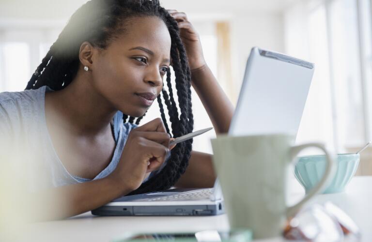 young woman leaning forward looking at laptop