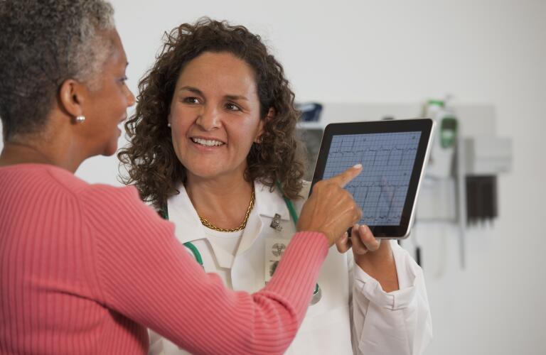 Doctor showing patient ekg test result on digital tablet