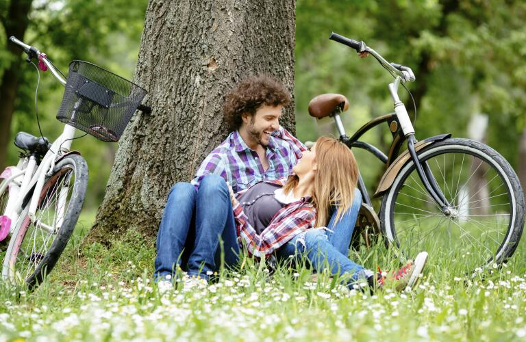Young couple enjoy break after riding bicycle outdoors.