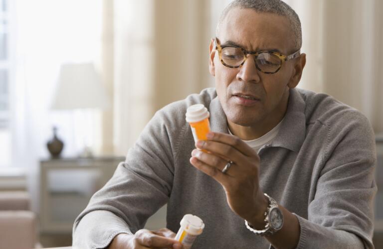 man-holding-two-bottles-of-pills