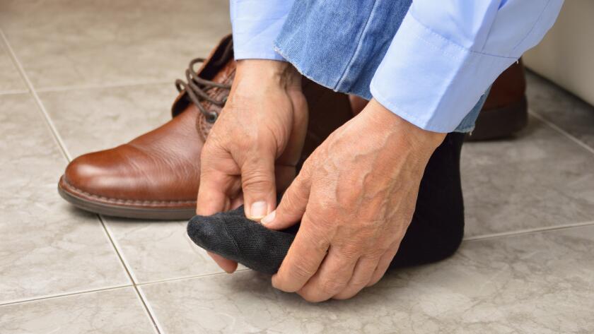 man bending over with foot pain