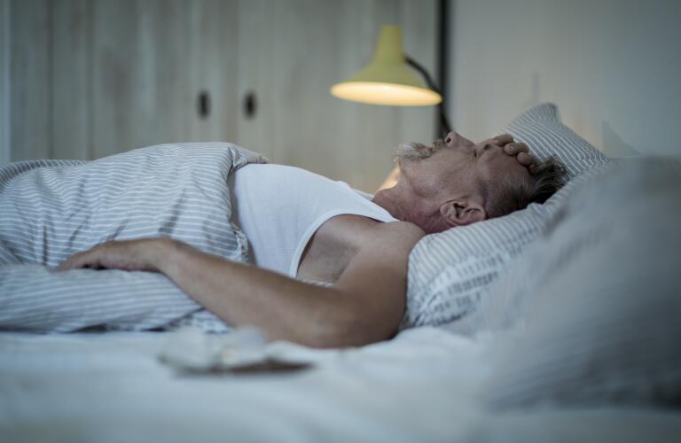  Homme caucasien âgé au lit avec insomnie 