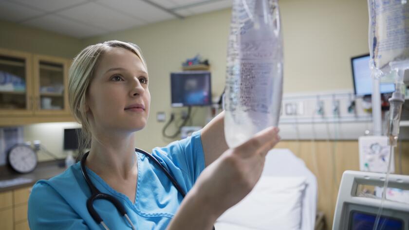 female nurse holding up infusion bag