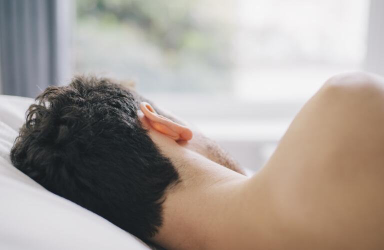 closeup of Caucasian male sleeping on side with view of back