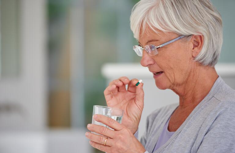 Senior mujer que toma la píldora