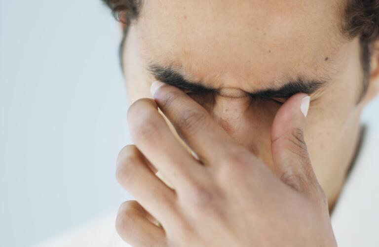 man rubbing eyes