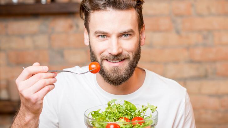 portrait-of-a-man-eating-salad-with-tomatoes
