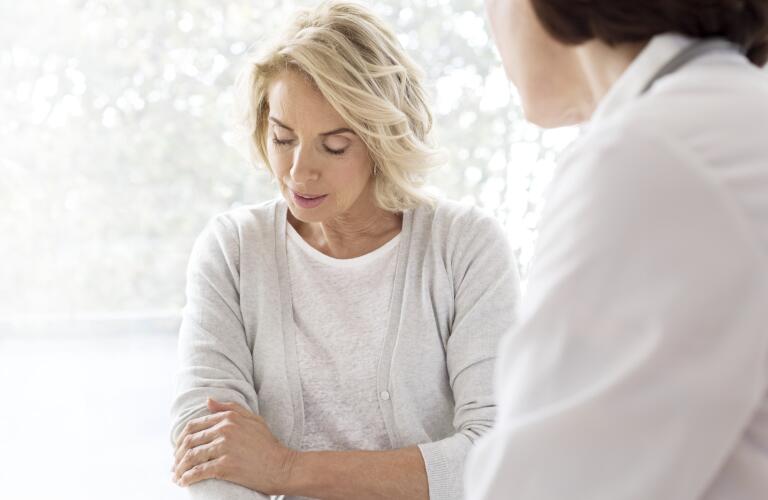 Middle aged Caucasian woman with arm pain at doctor