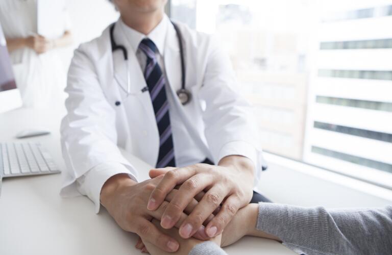 Doctor holding patient hand to give a support
