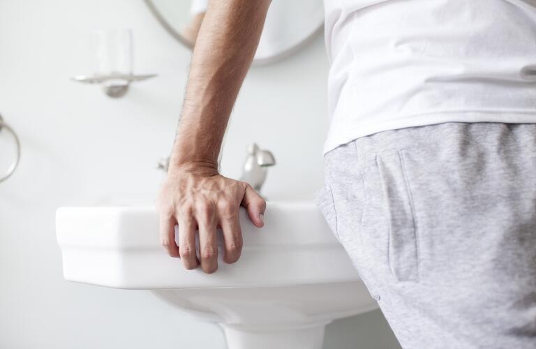 man leaning against sink in bathroom