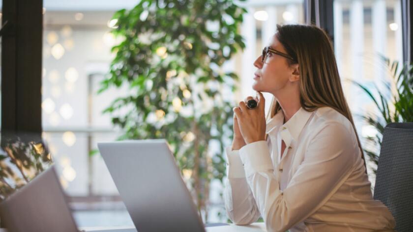Caucasian businesswoman thinking at desk in office