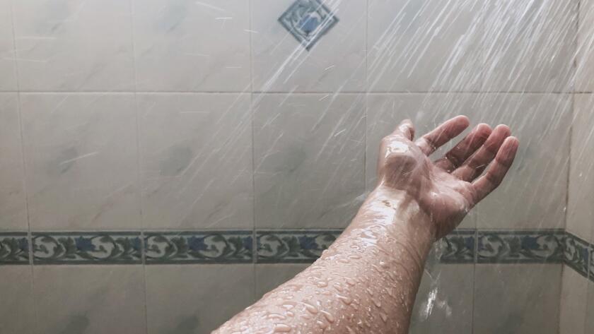water spraying on hand in shower