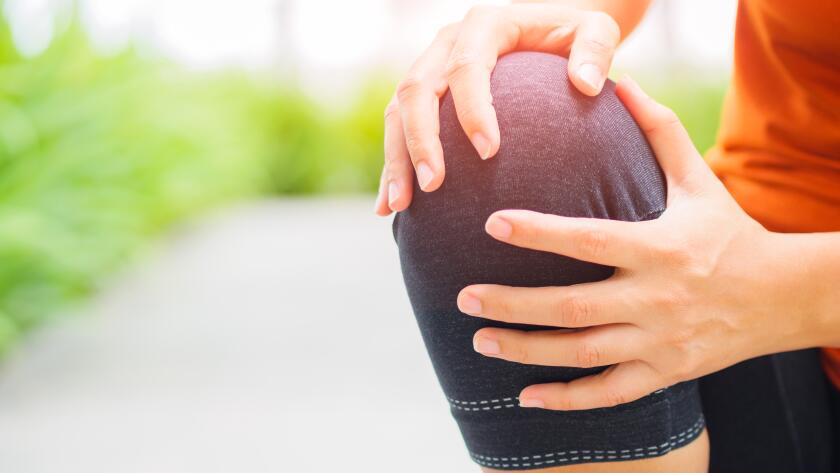 Close-up of young Caucasian female runner holding need in pain