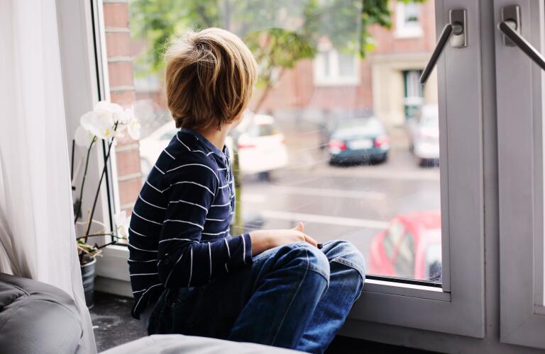 boy-sitting-down-looking-out-of-window