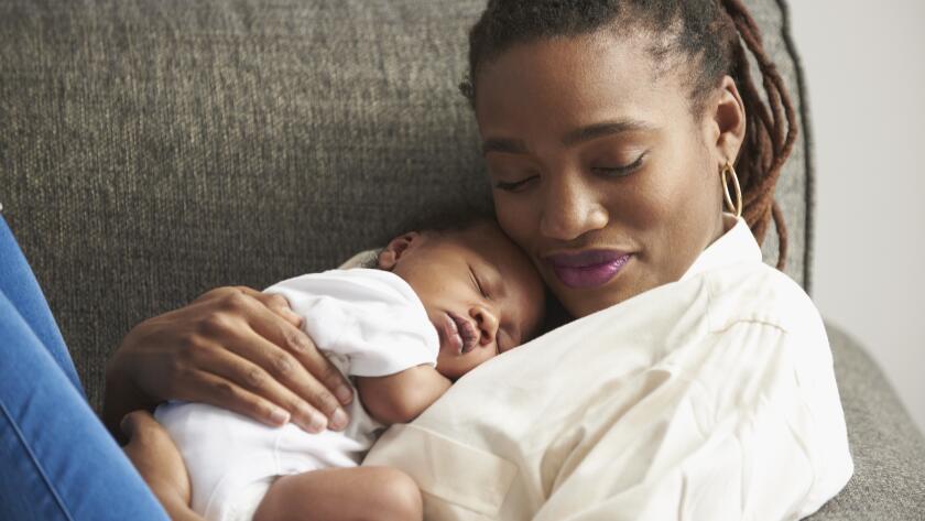 portrait of African American mother holding sleeping child