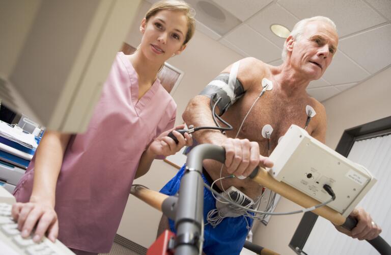 nurse with patient during heart stress test (electrocardiogram)