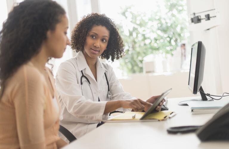 Doctor and patient using digital tablet in office