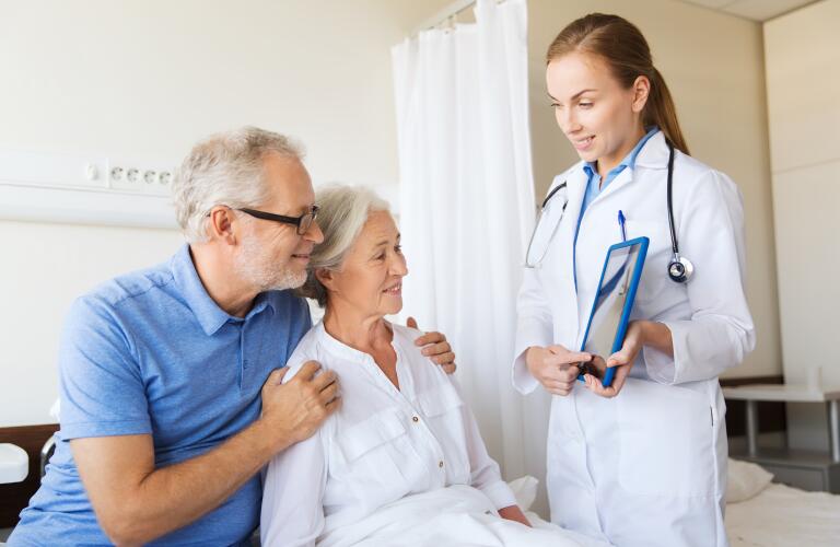 Senior woman and doctor with tablet pc at hospital