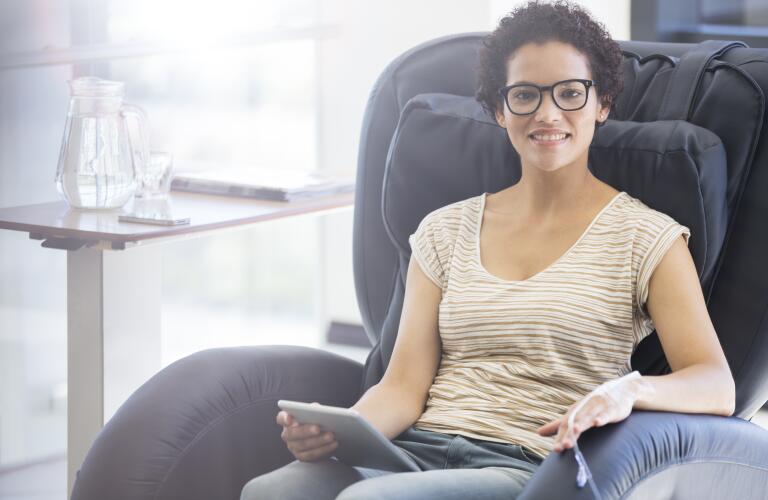 woman sitting in infusion chair with tablet