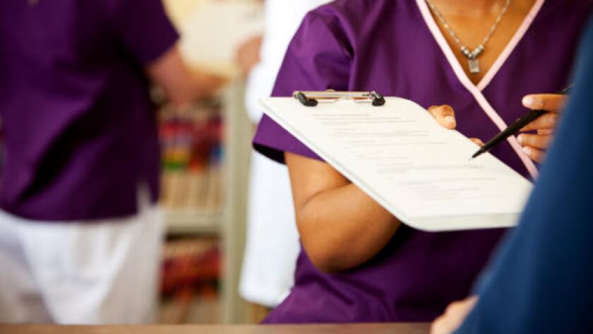 Doctor holding out clipboard