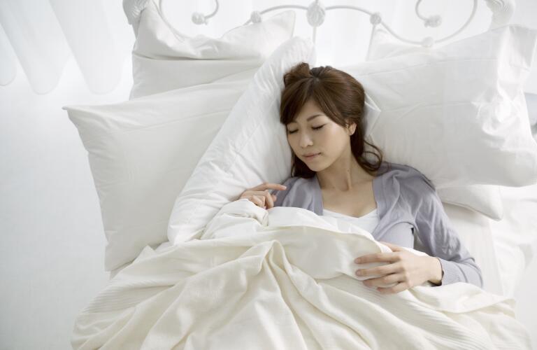 young woman sleeping soundly in bed