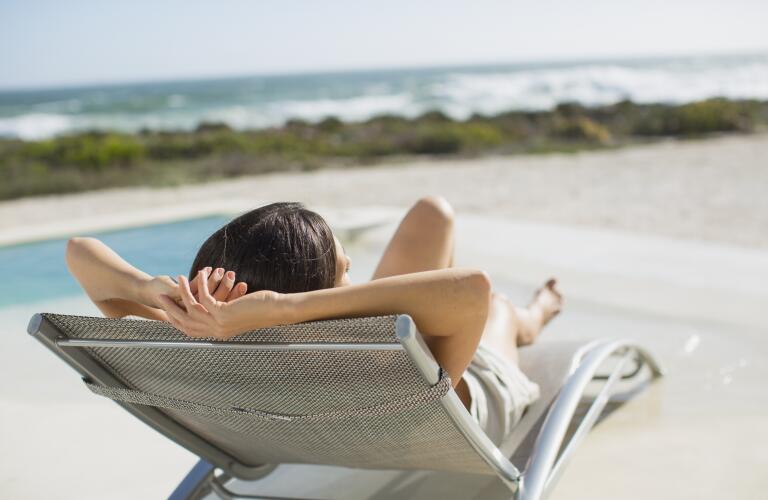 Woman sunbathing on lounge chair at poolside